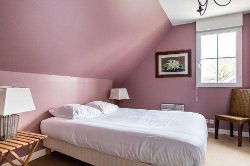 een slaapkamer met paarse muren, een bed en een raam bij Gîte La Cormorandière in Cancale