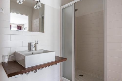 La salle de bains blanche est pourvue d'un lavabo et d'une douche. dans l'établissement Gîte Taumain, à Cancale