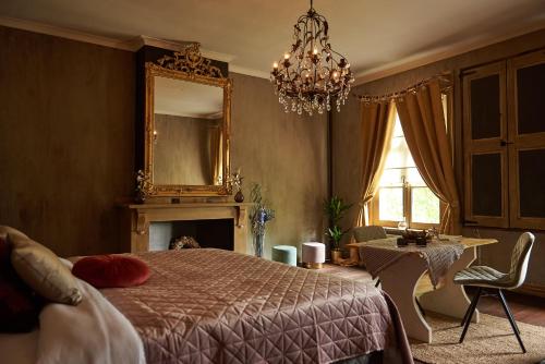 a bedroom with a bed and a mirror and a table at B&B Pura Vista in Zandhoven