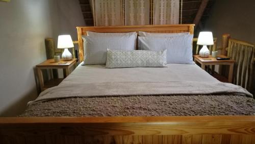 Cape Town的住宿－Teas & Seas Self Catering Cottage，一间卧室配有一张床,两台桌子上放着两盏灯