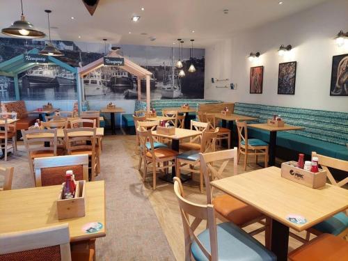 a restaurant with wooden tables and chairs in a room at Newquay Caravan Holiday in Newquay