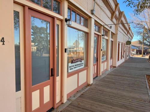 a row of doors on a building with a sidewalk at Katie's Cozy Suites in Tombstone