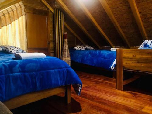 a room with two beds in a attic at Hospedaje Puntzán in Baños