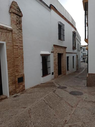 an empty alleyway next to a white building at Fernan Caballero in Carmona