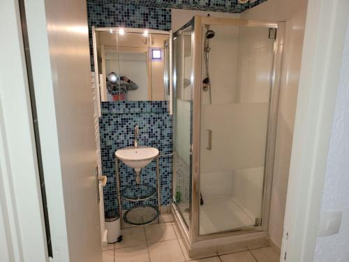 une salle de bain avec un lavabo et une douche dans l'établissement Studio avec loggia entre port, plage et piscine, au Grau-du-Roi