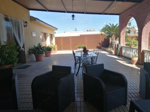 a patio with a table and chairs on a patio at Villa Paquita - Delta de l'Ebre in Deltebre