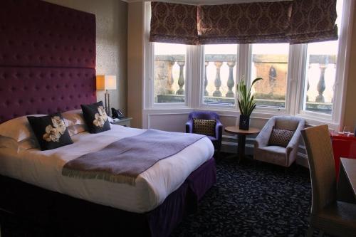 a hotel room with a large bed and windows at 24 Royal Terrace in Edinburgh