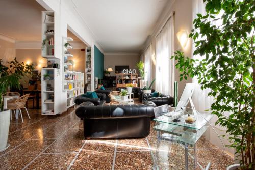 uma sala de estar com um sofá de couro preto e mesas em Hotel Tigullio em Lavagna