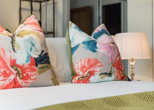 a white bed with pillows on it with a lamp at Riverside 2- Bedroom Apartments in London