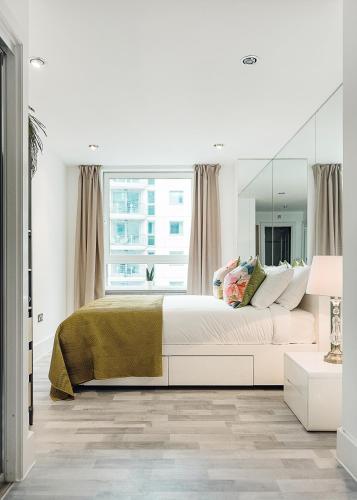a bedroom with a large bed and a large mirror at Riverside 2- Bedroom Apartments in London