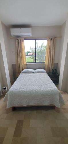 a bedroom with a large bed and a window at NCG SUITE SAMANES in Guayaquil