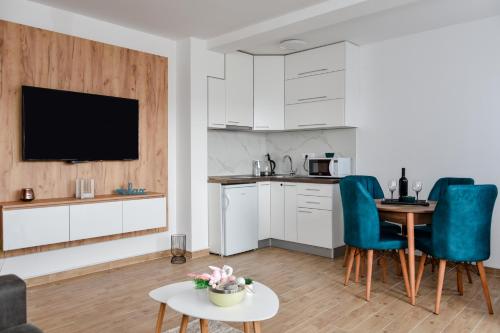 a kitchen with white cabinets and a table and chairs at Vuković Lux in Vrnjačka Banja