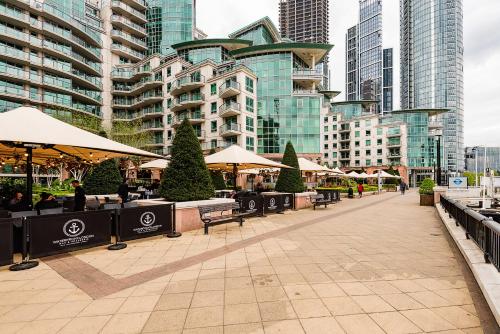 a city street with tables and umbrellas and buildings at Riverside 2- Bedroom Apartments in London