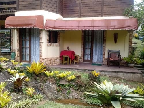 a house with a table and chairs in front of it at OYO Pousada Luar da Serra Lumiar in Lumiar