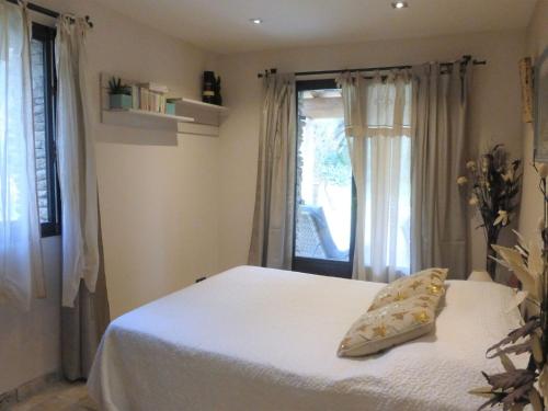 1 dormitorio con cama blanca y ventana en holiday home, Bédarrides, en Bédarrides