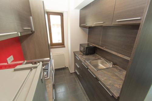 a small kitchen with a sink and a microwave at Miraj Apartaments - Exclusive Residence in Mamaia