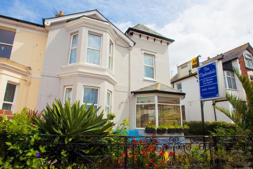 a white house with a blue sign in front of it at The Clydesdale in Paignton