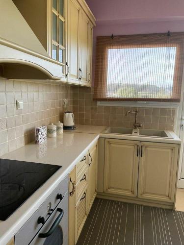 a kitchen with white cabinets and a sink at Dream House in Preveza