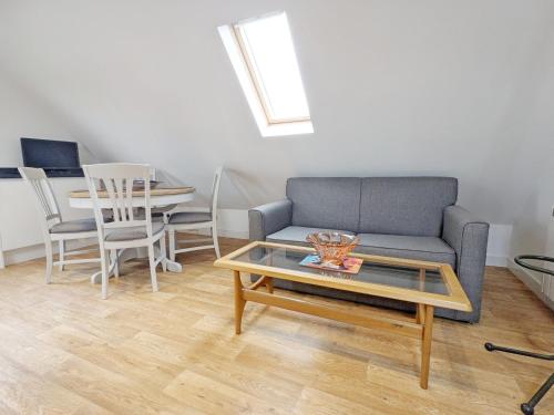 a living room with a couch and a table at Carthagena, Birdham in Chichester