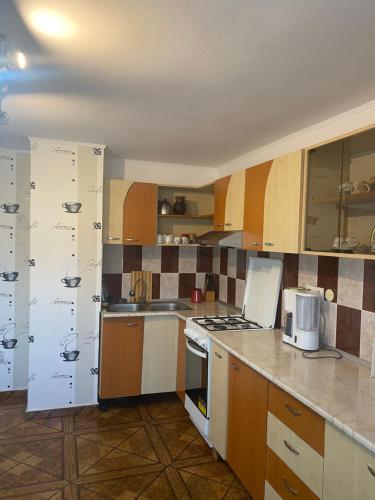 a kitchen with white appliances and wooden cabinets at Casa Oana Ioana in Moieciu de Jos
