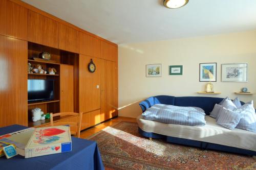 a living room with a blue couch and a tv at Ferienappartement Regina in Schrems