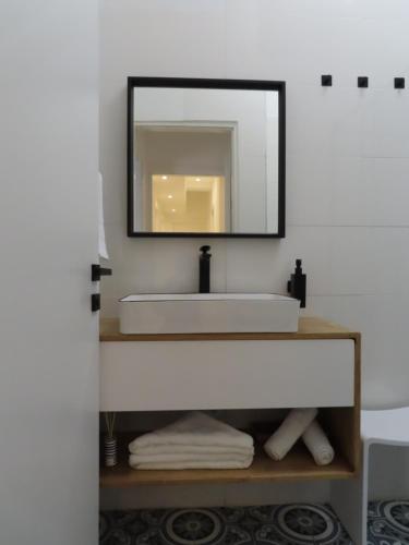 ein Badezimmer mit einem weißen Waschbecken und einem Spiegel in der Unterkunft B12 Inn in Jerusalem
