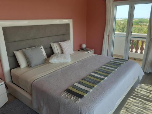 - une chambre avec un grand lit et une grande fenêtre dans l'établissement Alojamento local Patudos, Suite com terraço privado, à Tavira