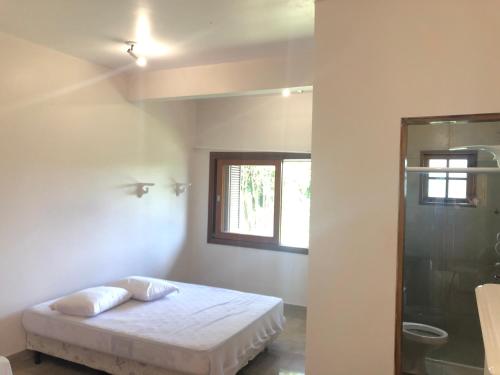 um quarto com uma cama, uma janela e um chuveiro em Casa encantadora com piscina aquecida em condomínio em Campo Limpo