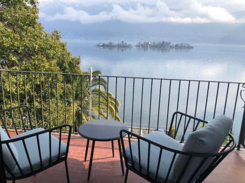 a balcony with chairs and a table and a view of the water at Residenza Bettina BnB & Ferienwohnungen in Ronco s/Ascona - Porto Ronco