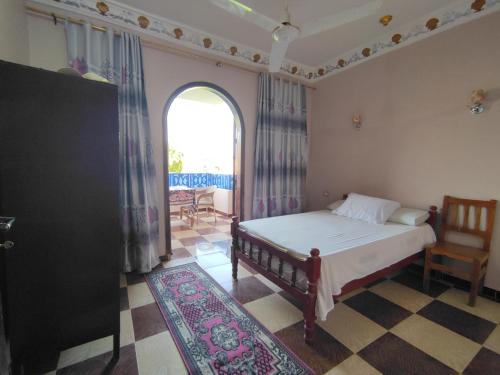 a bedroom with a bed and a large window at Ahmed Mulatam House in Luxor