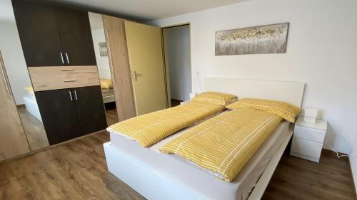 a bedroom with a bed with yellow pillows on it at Holiday Apartments Falke in Brienz