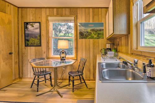 a kitchen with a sink and a table and chairs at Peaceful Spruce Pine Cabin on 8 Acres with 2 Decks! in Spruce Pine