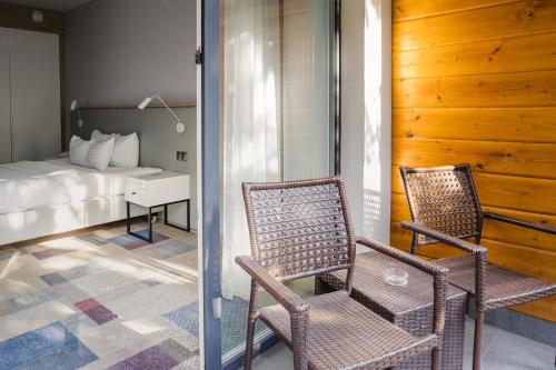 2 sillas en una habitación con 1 cama y 1 dormitorio en Magnus Resort, en Szczyrk