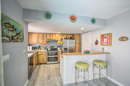 a kitchen with wooden cabinets and a counter with bar stools at Heated Pool and Lanai Matlacha Isles Getaway in Matlacha