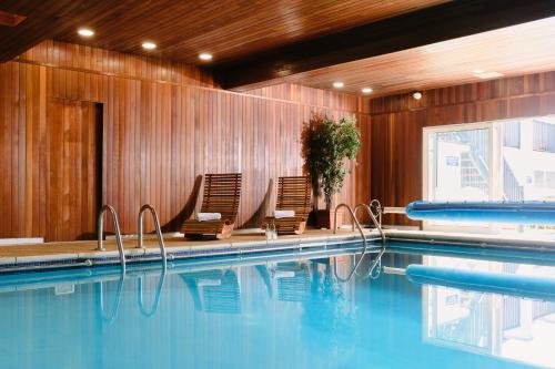 a swimming pool with two chairs and a swimming pool at The Kilbirnie Hotel in Newquay