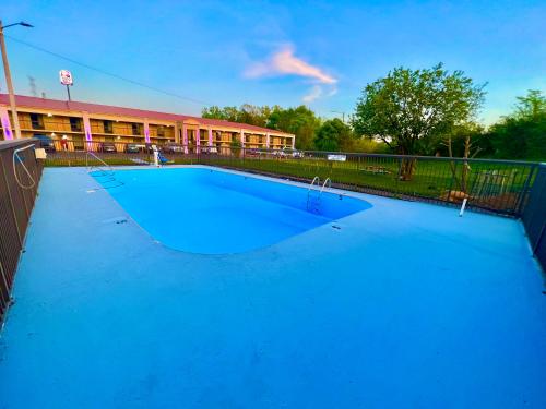 a large blue swimming pool in front of a building at Days Inn by Wyndham Athens in Athens