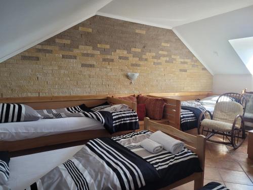 Zimmer mit 3 Betten und Ziegelwand in der Unterkunft Koba in Bački Monoštor