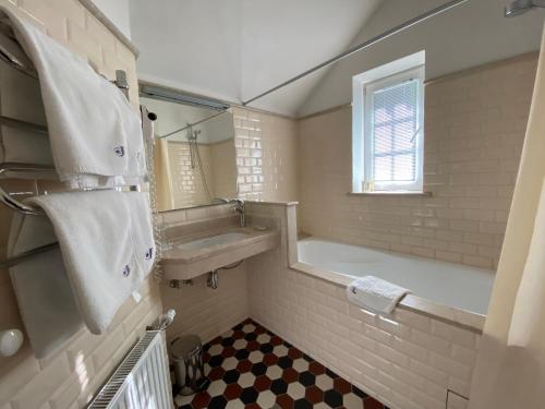 a bathroom with a tub and a sink and a mirror at Villa Joma in Jūrmala