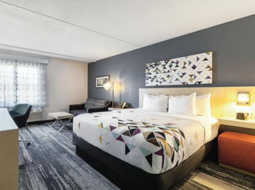 a hotel room with a bed and a desk at Baymont by Wyndham White Plains - Elmsford in Elmsford