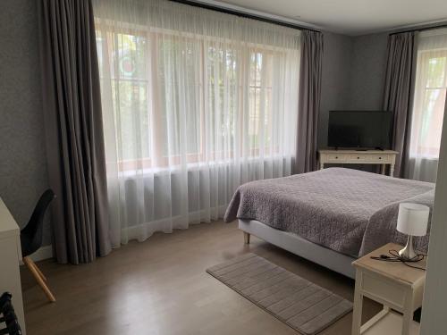 a bedroom with a bed and a large window at Villa Joma in Jūrmala