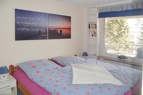 een slaapkamer met een bed met een foto aan de muur bij Carpe Diem Carpe Diem Appartement 109 in Niendorf