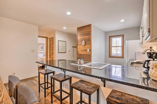 a kitchen with a counter with stools and a sink at Private Balcony and Resort Perks Silverthorne Condo in Silverthorne