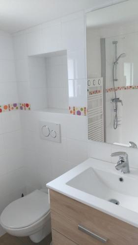 une salle de bain blanche avec des toilettes et un lavabo dans l'établissement studio indépendant neuf proche mer, à Saint-Hilaire-de-Riez