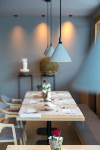 a long table in a room with chairs and lights at Olympic SPA Hotel - Adults Only in Vigo di Fassa