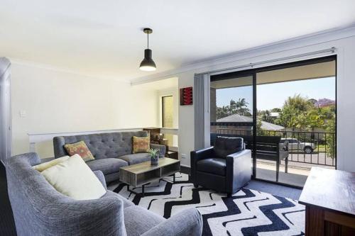 a living room with a couch and a chair at Bright Private Room in Pleasant Ashmore in Gold Coast