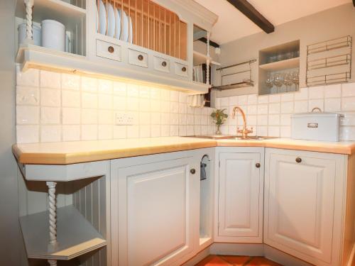 a kitchen with white cabinets and a sink at 4 Trenhaile Terrace in Truro