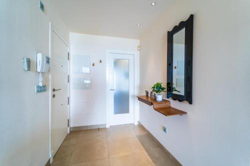 a hallway with a mirror and a door at Primera línea de mar con piscina, gimnasio y parking 2 hab y 2 baños in Villajoyosa