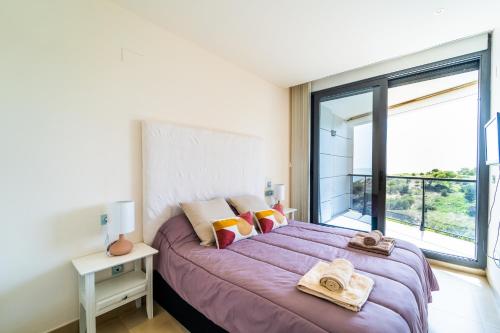 a bedroom with a purple bed with a large window at Primera línea de mar con piscina, gimnasio y parking 2 hab y 2 baños in Villajoyosa