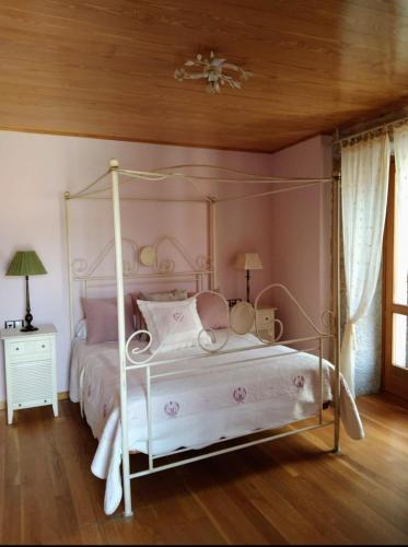 a bedroom with a white canopy bed with a wooden ceiling at Casa Rosalia in Lobios