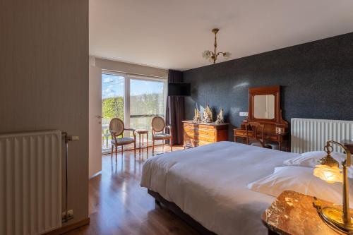 a bedroom with a large bed and a table and chairs at Apollonia in Aalter